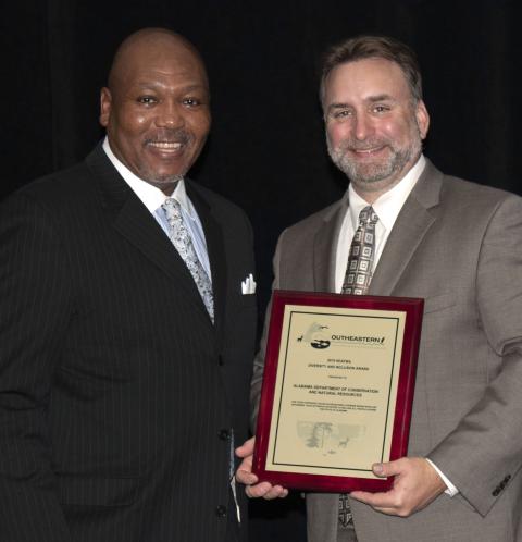 The director of the winning Alabama agency stands next to the head of the award committee