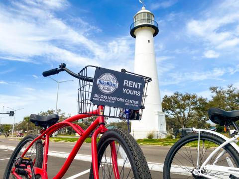 Red bike in front of white lighthouse
