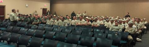 Wildlife officers sit in chairs in a conference room during a Hurricane Irma briefing