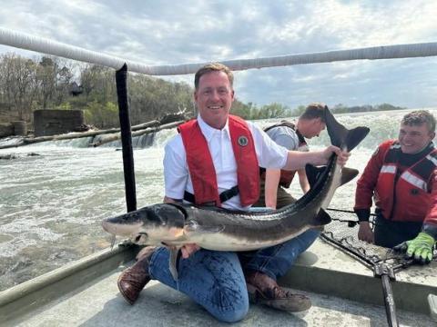 Newly appointed Director of the Missouri Department of Conservation, Jason Sumners, holding a sturgeon on a boat deck
