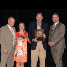 The award winner poses with a plaque next to the SEAFWA president and the award committee chairs